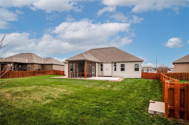 rear view of property featuring a lawn, a patio area, a fenced backyard, and a sunroom