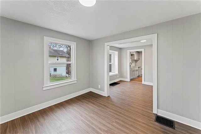 unfurnished room with hardwood / wood-style floors