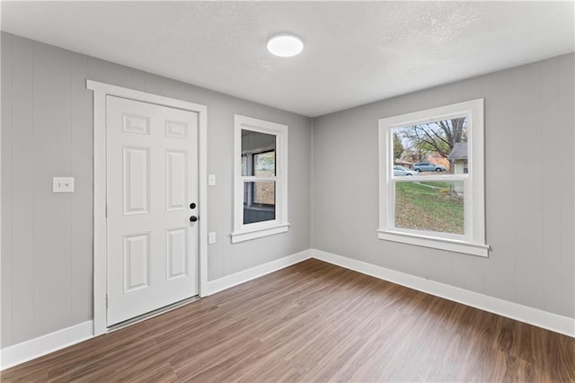 spare room with wood walls, hardwood / wood-style floors, and a textured ceiling