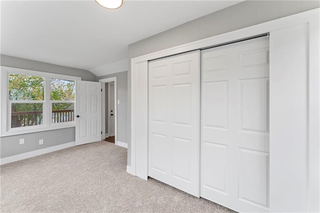 unfurnished bedroom with a closet and light colored carpet