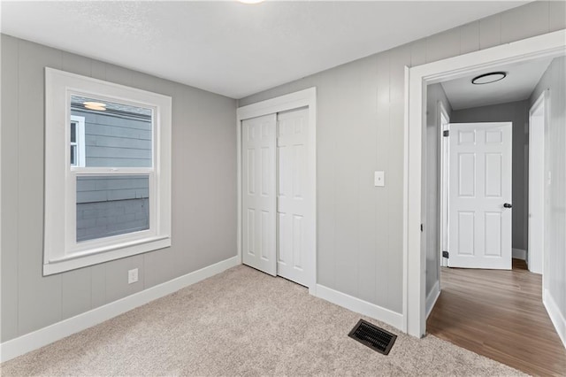 unfurnished bedroom with a closet and hardwood / wood-style floors