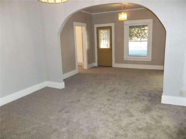 carpeted foyer with crown molding