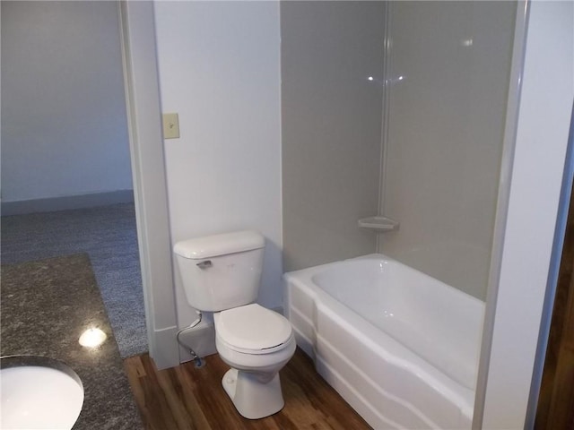 full bathroom with sink, washtub / shower combination, wood-type flooring, and toilet