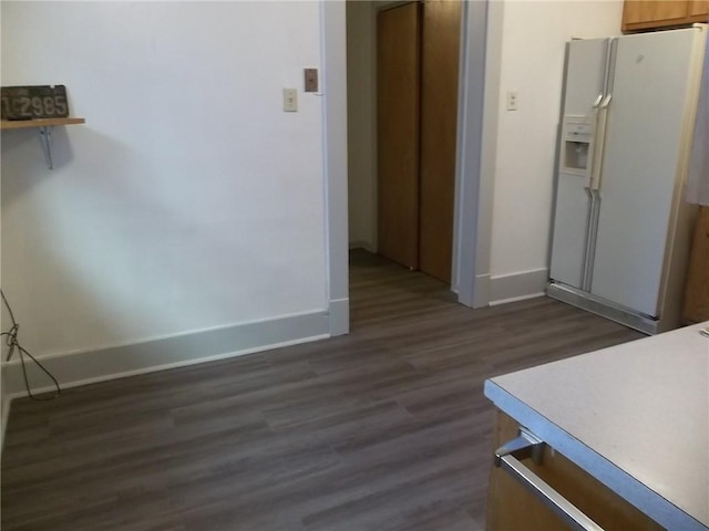 kitchen featuring dark hardwood / wood-style flooring and white fridge with ice dispenser