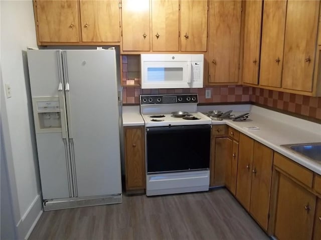 kitchen featuring decorative backsplash, dark hardwood / wood-style flooring, and white appliances