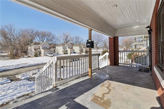 snow covered patio featuring a porch