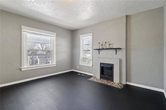 unfurnished living room with a textured ceiling and dark hardwood / wood-style flooring