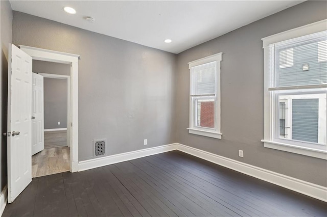 empty room featuring dark hardwood / wood-style floors and a healthy amount of sunlight