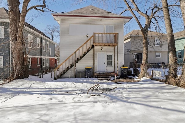 snow covered back of property with central AC