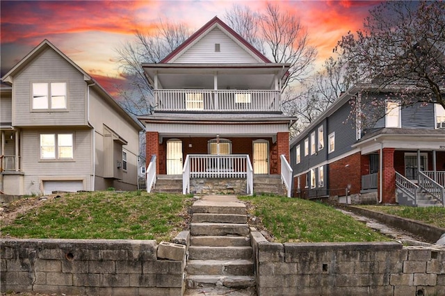 3231 Park Ave, Kansas City, MO 64109 - view of front facade featuring stairs, a porch, a balcony, and brick siding
