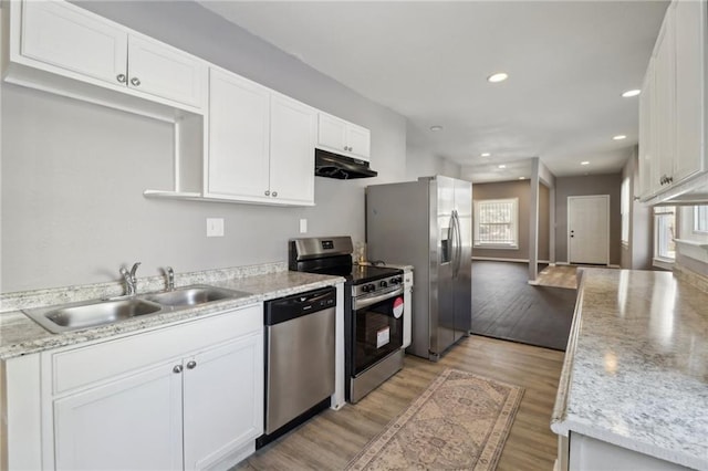 3231 Park Ave, Kansas City, MO 64109 - kitchen featuring under cabinet range hood, light wood-style flooring, appliances with stainless steel finishes, white cabinetry, and a sink