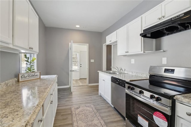 3231 Park Ave, Kansas City, MO 64109 - kitchen with light wood finished floors, a sink, stainless steel appliances, under cabinet range hood, and white cabinetry
