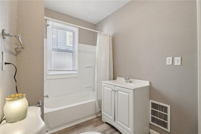 3231 Park Ave, Kansas City, MO 64109 - bathroom featuring visible vents, shower / tub combo with curtain, a textured wall, wood finished floors, and a sink