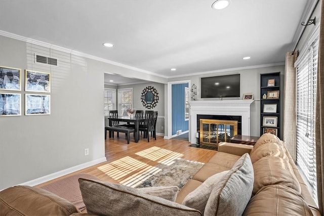 living room featuring hardwood / wood-style flooring, plenty of natural light, and ornamental molding