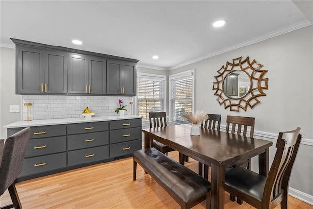 dining space with light hardwood / wood-style floors and ornamental molding