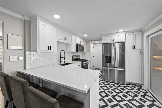 kitchen featuring sink, kitchen peninsula, crown molding, white cabinets, and appliances with stainless steel finishes