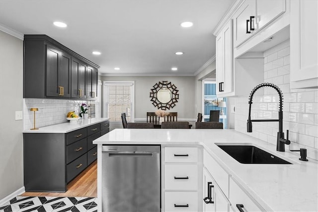 kitchen with stainless steel dishwasher, white cabinetry, sink, and ornamental molding