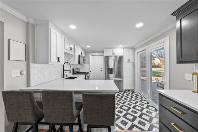 kitchen with a kitchen breakfast bar, kitchen peninsula, sink, and appliances with stainless steel finishes