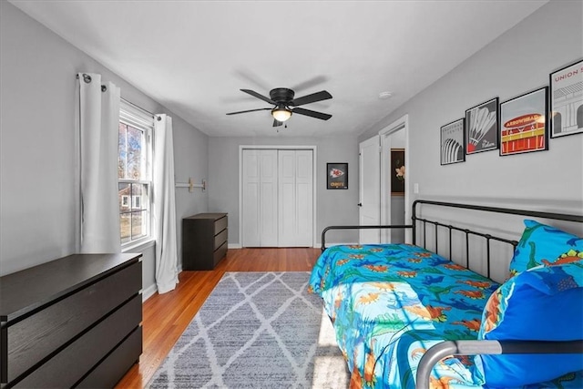 bedroom with a closet, light hardwood / wood-style flooring, and ceiling fan