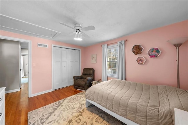 bedroom with ceiling fan, light hardwood / wood-style floors, and a closet