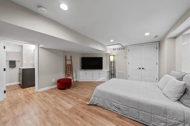 bedroom with light hardwood / wood-style floors, a closet, and sink