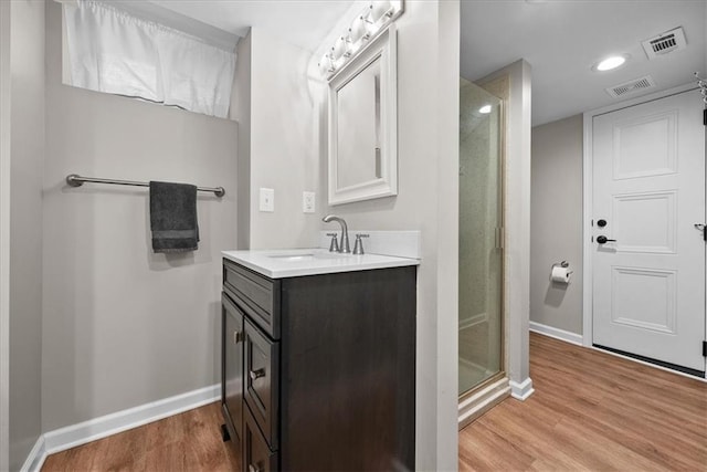 bathroom featuring hardwood / wood-style floors, vanity, and walk in shower