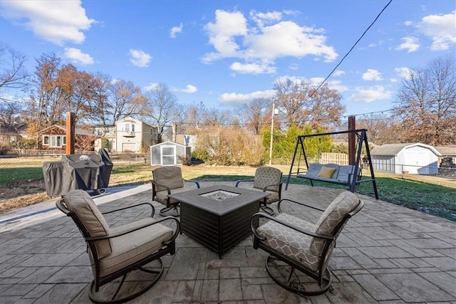 view of patio / terrace featuring area for grilling, a shed, and a fire pit