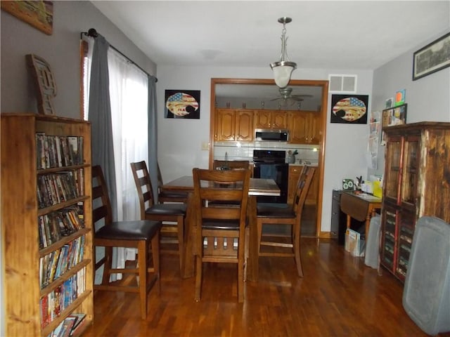 dining area with ceiling fan and dark wood-type flooring