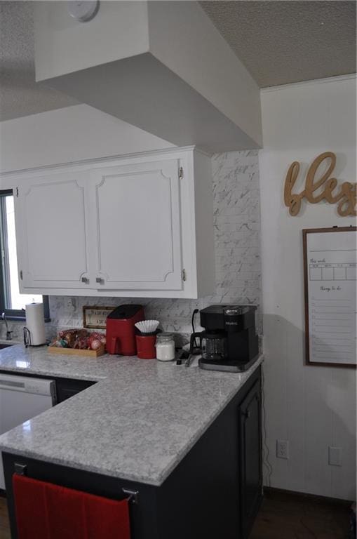 kitchen with white cabinets, backsplash, a textured ceiling, and white dishwasher