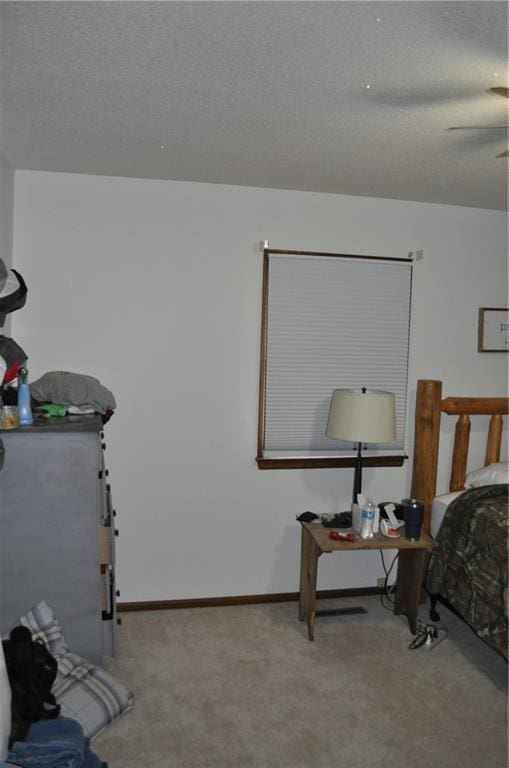 bedroom featuring ceiling fan, carpet, and a textured ceiling