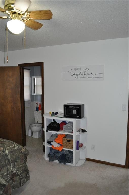 carpeted bedroom with ceiling fan and ensuite bath