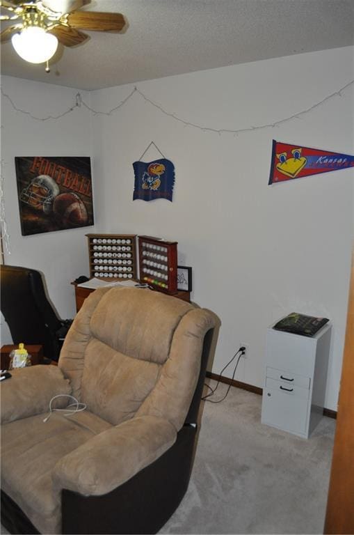 living area featuring light carpet and ceiling fan