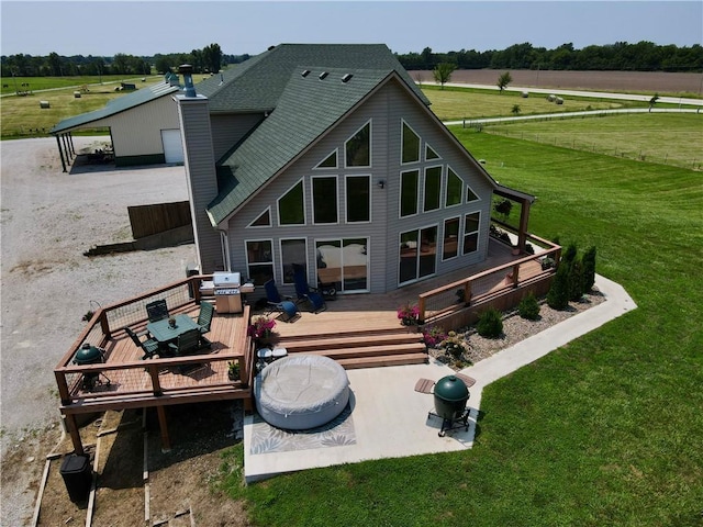 rear view of property featuring a yard, a rural view, and a deck