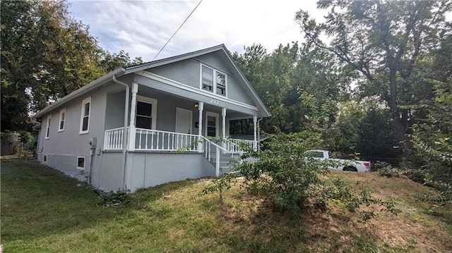 view of front of home with covered porch and a front yard