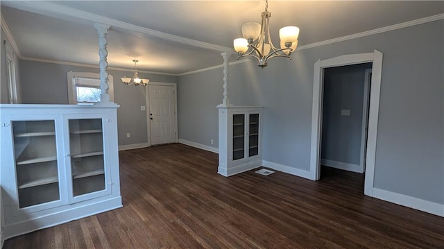 interior space with dark wood-type flooring, a chandelier, and ornamental molding