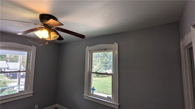 empty room featuring plenty of natural light and ceiling fan