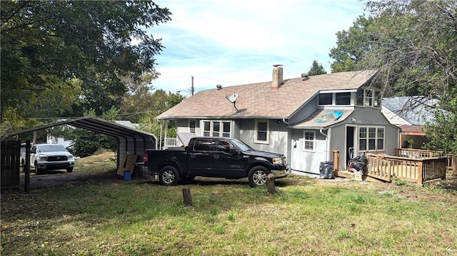 back of property featuring a carport, a lawn, and a wooden deck