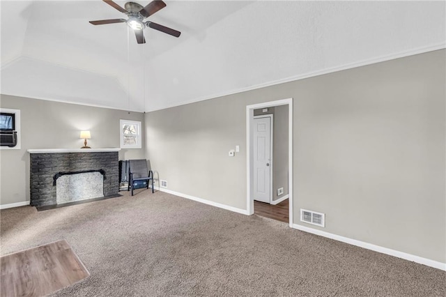 unfurnished living room with carpet, ceiling fan, a fireplace, and vaulted ceiling