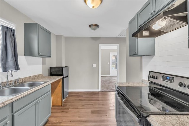 kitchen with light wood-type flooring, backsplash, sink, electric range, and gray cabinets