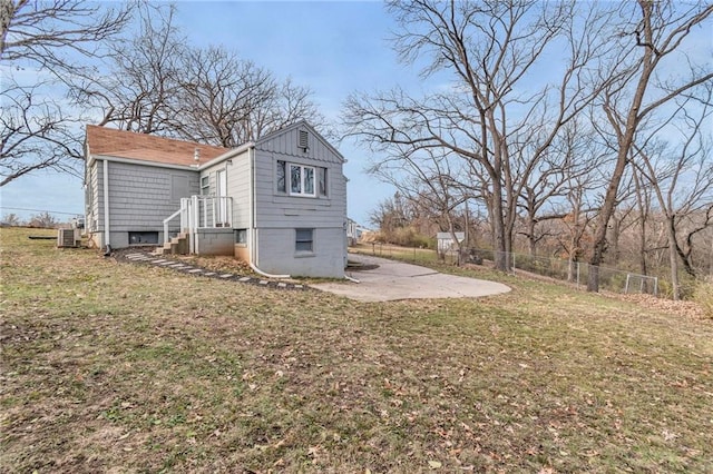 view of side of home with central AC, a yard, and a patio