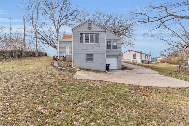 back of house featuring a garage and a yard