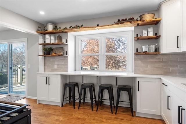 kitchen featuring white cabinets, a healthy amount of sunlight, and light wood-type flooring