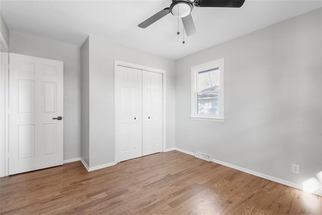 unfurnished bedroom with ceiling fan, a closet, and hardwood / wood-style flooring