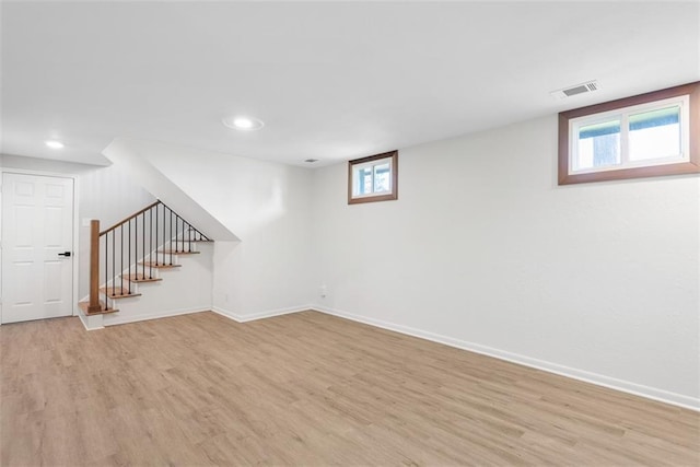 basement with light wood-type flooring and a healthy amount of sunlight