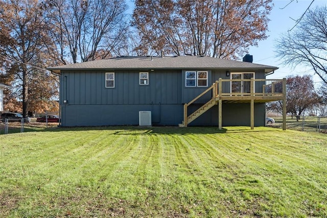 rear view of property with a yard, central AC unit, and a wooden deck