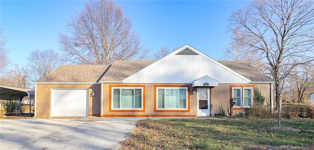 view of front of property featuring a carport, a garage, and a front yard