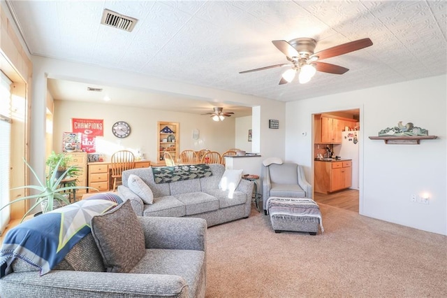 carpeted living room featuring ceiling fan