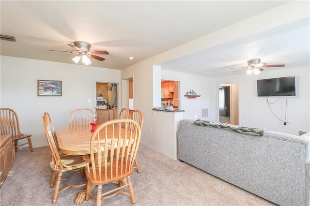 carpeted dining area featuring ceiling fan