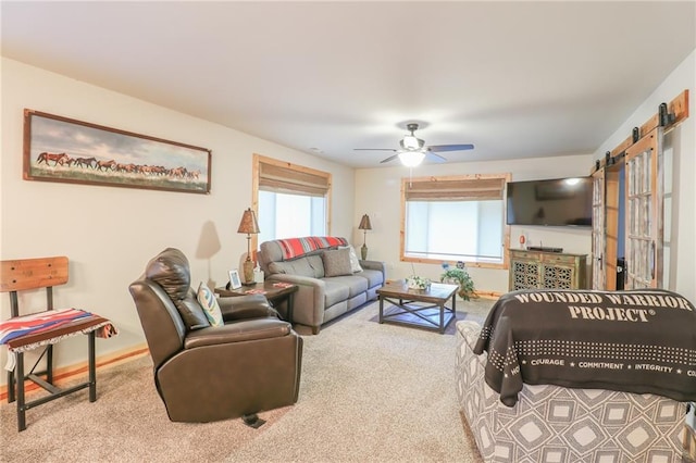 living room featuring light carpet, a barn door, and ceiling fan