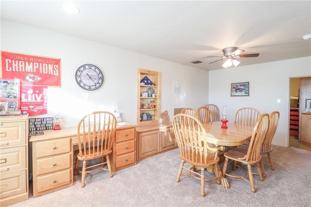 carpeted dining area with ceiling fan